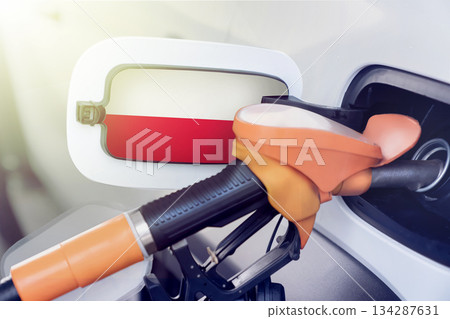 The Polish flag on the lid of the gas tank of a car at a gas station in close-up. High or low prices for gasoline and diesel fuel at Polish gas stations. shortage of fuel for cars in Poland. The Polish flag on the lid of the gas tank of a car at a gas station in close-up. High or low prices for gasoline and diesel fuel at Polish gas stations. shortage of fuel for cars in Poland. 134287631