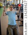 Motivated disabled man in wheelchair do pull ups in gym, working out on building upper body strength 134289827
