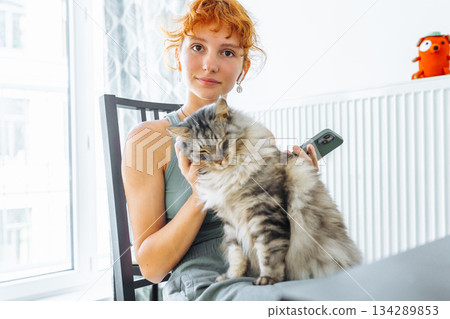 young woman spends time with her pet cat young woman spends time with her pet cat 134289853