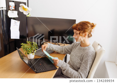 Young woman using multiple laptops for video conferencing at home office Young woman using multiple laptops for video conferencing at home office 134289934