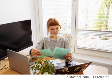 Young woman using multiple laptops for video conferencing at home office Young woman using multiple laptops for video conferencing at home office 134289936