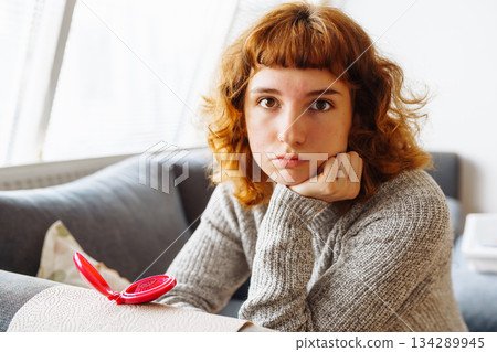 young woman looks at problematic facial skin in mirror 134289945