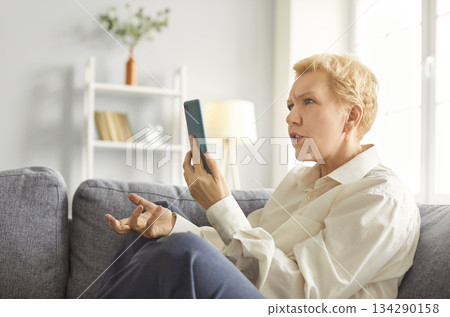 Angry Elderly Woman Talking On Video Call At Home Angry Elderly Woman Talking On Video Call At Home 134290158