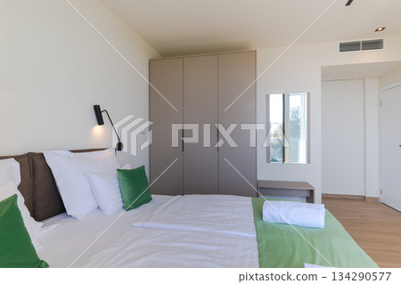Modern open-plan living and dining room in a luxury villa with large glass doors opening to a private swimming pool, offering a spacious and elegant indoor-outdoor living experience 134290577