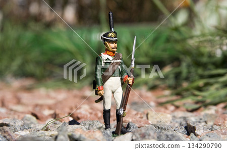 Closeup photo of the toy soldier placed on a gravel in the garden Closeup photo of the toy soldier placed on a gravel in the garden 134290790