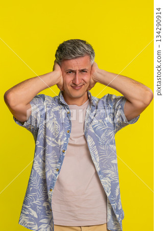 Adult man covering ears and shaking head with denial refusing to hear anything with strong rejection 134290914
