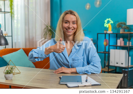 Young businesswoman showing thumbs up like sign positive something good great news positive feedback 134291167