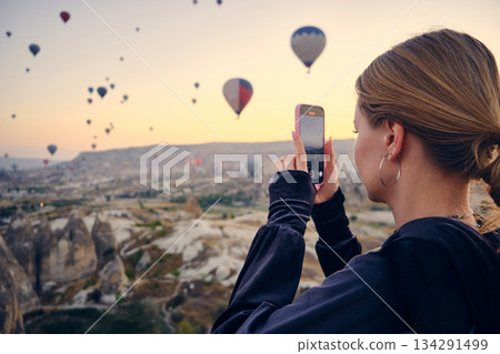 Traveler Photographing Hot Air Balloons at Sunrise 134291499