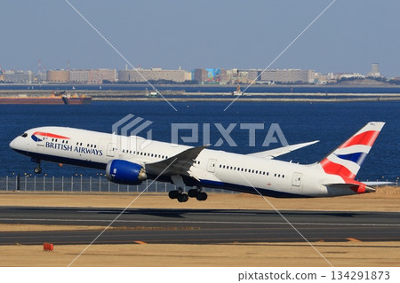 一架客機起飛並爬升。一架英國航空公司的飛機從羽田機場起飛。 134291873