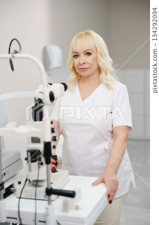Ophthalmologist with eye exam tools in office Ophthalmologist with eye exam tools in office 134292094