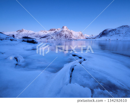 Lofoten islands, Norway. Nature in the fjords during winter night. Mountains, ice and reflections. Lofoten islands, Norway. Nature in the fjords during winter night. Mountains, ice and reflections. 134292610