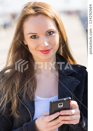 Girl using mobile phone texting on smartphone Girl using mobile phone texting on smartphone 134292664