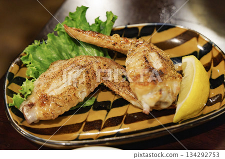 Close-up of grilled chicken wings and lemon 134292753