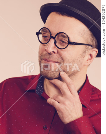 Adult man wearing funny hat and eyeglasses 134292875
