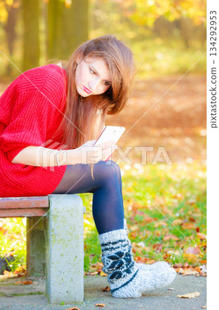 Sad woman in park with phone. Sad woman in park with phone. 134292953