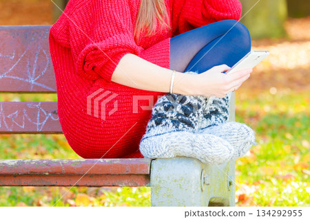 Sad girl in park with mobile phone Sad girl in park with mobile phone 134292955