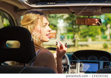 Girl apply make up while driving car. Girl apply make up while driving car. 134293382