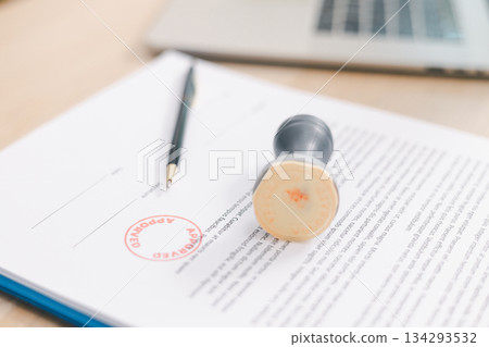 Close up approved stamp on signed document with pen on desk, concept of successful business contract, legal authorization, agreement approval or financial verification process. approved stamp Close up approved stamp on signed document with pen on desk, concept of successful business contract, legal authorization, agreement approval or financial verification process. approved stamp 134293532