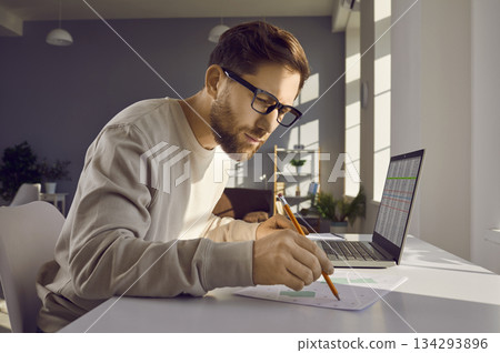 Professional cartographer working with printed cadastral map at table on his workplace. Professional cartographer working with printed cadastral map at table on his workplace. 134293896