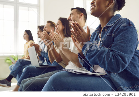 Satisfied diverse audience of students or workers applauding during lecture or seminar. 134293901