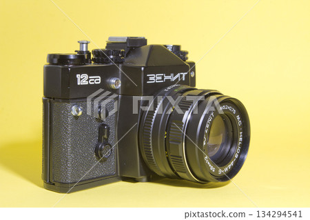 Vintage photo camera on yellow background Vintage photo camera on yellow background 134294541