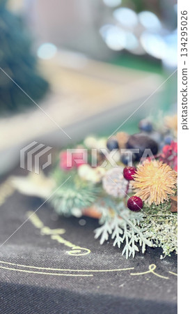 A wreath placed next to a Christmas tree 134295026