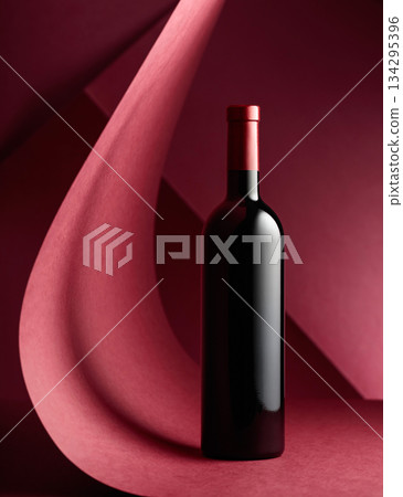 Bottle of red wine on a red background. 134295396