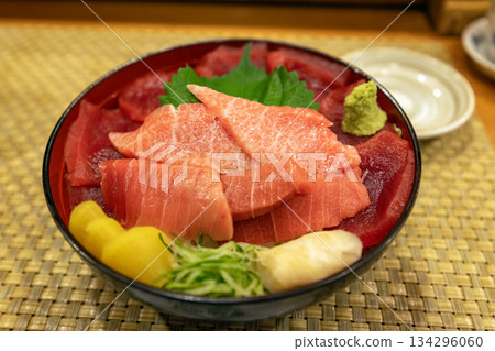 一份奢華的海鮮蓋飯,上面鋪滿了肥美的金槍魚腩和精瘦的金槍魚。 一份奢華的海鮮蓋飯,上面鋪滿了肥美的金槍魚腩和精瘦的金槍魚。 134296060