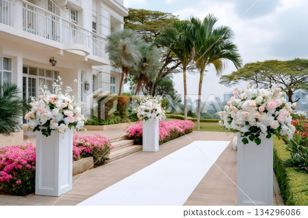 Outdoor wedding ceremony aisle with flowers and white carpet 134296086