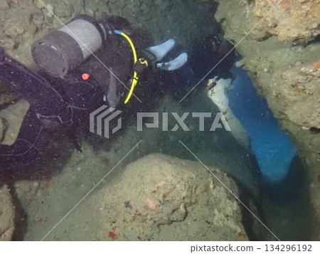 Diver swimming through a dark sea cave Diver swimming through a dark sea cave 134296192