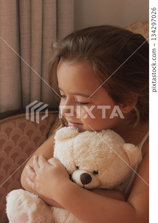 Genuine happiness: a smiling girl embraces her teddy bear with overwhelming affection Genuine happiness: a smiling girl embraces her teddy bear with overwhelming affection 134297026