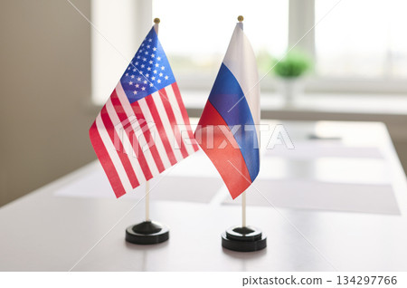 US and Russia mini desk flags showcasing diplomacy on conference negotiation table 134297766