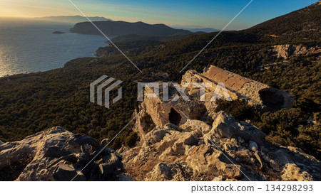 Ancient stone ruins overlooking a lush forest and the Aegean Sea Ancient stone ruins overlooking a lush forest and the Aegean Sea 134298293