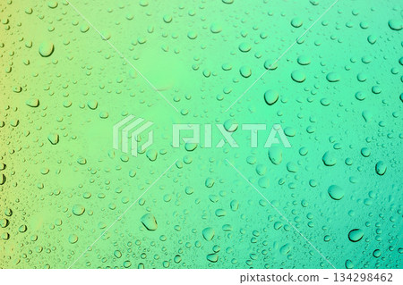 Abstract macro texture of clear water droplets on a soft green gradient background, representing fresh condensation, rain, or dew on a glass surface. Abstract macro texture of clear water droplets on a soft green gradient background, representing fresh condensation, rain, or dew on a glass surface. 134298462