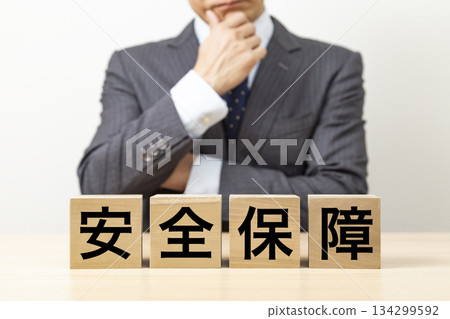 一塊寫著「安全」字樣的磚塊和一個商人 一塊寫著「安全」字樣的磚塊和一個商人 134299592