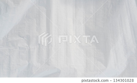White plastic tarpaulin texture with subtle folds and wrinkles, minimal abstract background. White plastic tarpaulin texture with subtle folds and wrinkles, minimal abstract background. 134301028