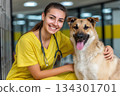 Veterinarian smiles next to a dog in a clinic. They enjoy a moment together in a busy animal care space 134301701