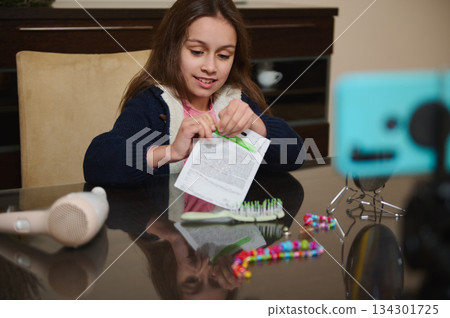 Young Girl Filming At Home While Crafting With Beads And Paper Document 134301725