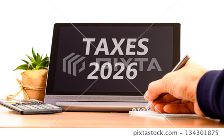 Taxes 2026 new year symbol. Concept words Taxes 2026 on beautiful black tablet screen. Beautiful white background. Businessman's hand. Business and taxes 2026 new year concept. Copy space. Taxes 2026 new year symbol. Concept words Taxes 2026 on beautiful black tablet screen. Beautiful white background. Businessman's hand. Business and taxes 2026 new year concept. Copy space. 134301875