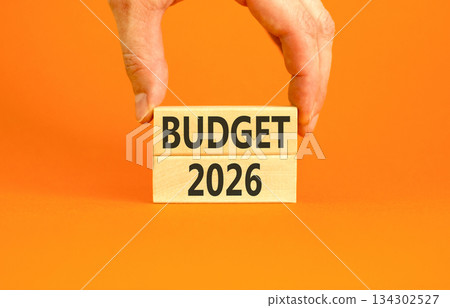 Budget 2026 symbol. Concept words Budget 2026 on beautiful wooden blocks. Beautiful orange paper background. Businessman's hand. Business and budget 2026 concept. Copy space. Budget 2026 symbol. Concept words Budget 2026 on beautiful wooden blocks. Beautiful orange paper background. Businessman's hand. Business and budget 2026 concept. Copy space. 134302527