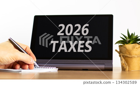 2026 taxes new year symbol. Concept words 2026 taxes on beautiful black tablet screen. Beautiful white background. Businessman's hand. Business and 2026 taxes new year concept. Copy space. 134302589
