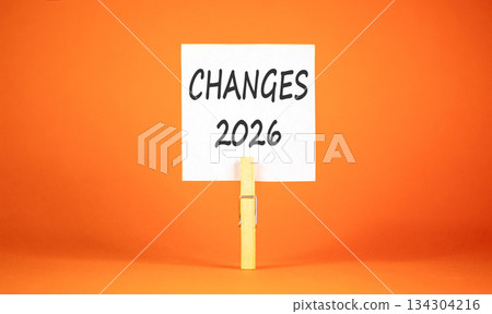 Changes 2026 symbol. Concept words Changes 2026 on beautiful white paper on wooden clothespin. Beautiful orange background. Business and changes 2026 concept. Copy space. Changes 2026 symbol. Concept words Changes 2026 on beautiful white paper on wooden clothespin. Beautiful orange background. Business and changes 2026 concept. Copy space. 134304216