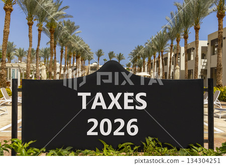 Taxes 2026 new year symbol. Concept words Taxes 2026 on beautiful black road sign. Beautiful palm trees palm-trees and blue sky background. Business and taxes 2026 new year concept. Copy space. Taxes 2026 new year symbol. Concept words Taxes 2026 on beautiful black road sign. Beautiful palm trees palm-trees and blue sky background. Business and taxes 2026 new year concept. Copy space. 134304251