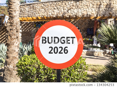 Budget 2026 symbol. Concept words Budget 2026 on beautiful white and red road sign. Beautiful palm trees palm-trees background. Business and budget 2026 concept. Copy space. Budget 2026 symbol. Concept words Budget 2026 on beautiful white and red road sign. Beautiful palm trees palm-trees background. Business and budget 2026 concept. Copy space. 134304253