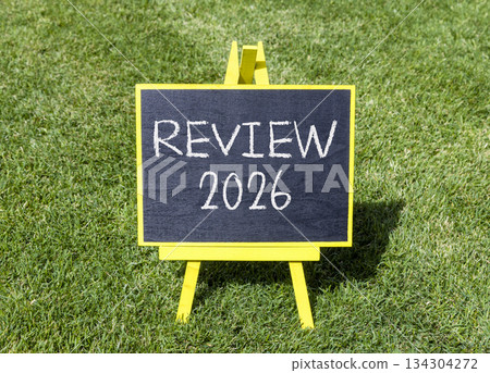 Review 2026 symbol. Concept words Review 2026 on beautiful black blackboard. Beautiful green grass background. Business and review 2026 concept. Copy space. 134304272