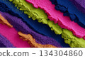 Macro, top-down view of richly textured, crumbled, brightly colored eyeshadow or pigment powder in vibrant stripes: magenta, lime green, navy, purple, and orange-gold. 134304860