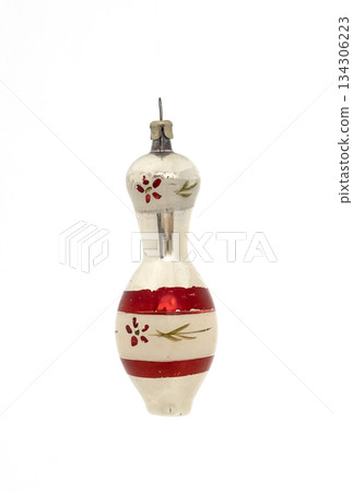 Vintage glass Christmas ornament with red stripes and floral details isolated on white background. 134306223