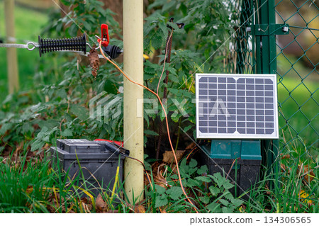 Small Solar farm, View of a small solar panel connected to a fence on a farm. 134306565