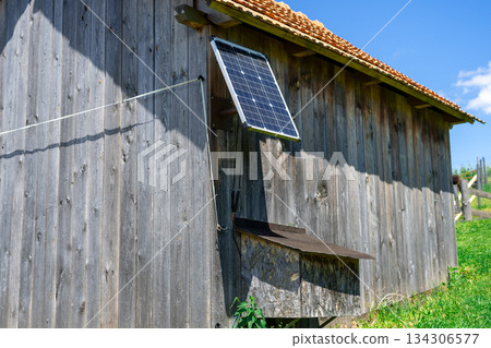 View of a small solar panel installed on a rural barn of a small farm, producing electricity. Ecological electricity production 134306577