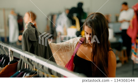 A Woman Engaging in Shopping for Trendy Clothes Within an Upscale Boutique Environment 134308144
